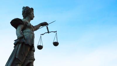 Statue of Lady Justice against blue sky