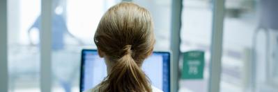 woman in labcoat looking at a computer